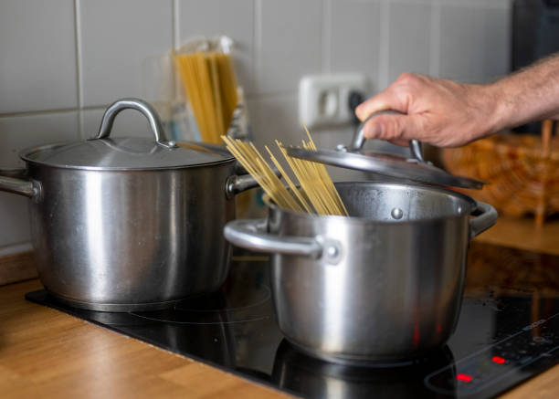 04 June 2022, Berlin: A man puts a lid on a pot of boiling water and spaghetti noodles. Photo: Monika Skolimowska/dpa (Photo by Monika Skolimowska/picture alliance via Getty Images)