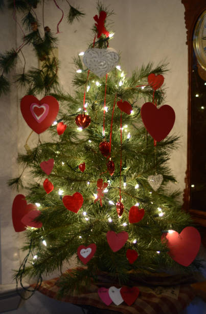 A Christmas tree that is decorated with Valentine's day themed decorations.